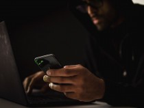 Hacker Using a Phone and a Laptop