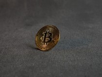 A Golden Bitcoin on a Grey Surface