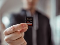 Person Holding Sandisk 64gb Microsd Adapter