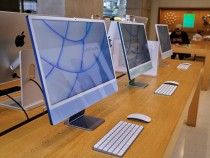 Apple's iMac products on a table in an Apple store.