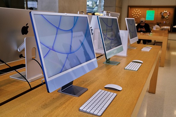 Apple's iMac products on a table in an Apple store.
