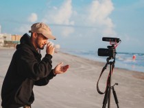 man in black jacket holding camera during daytime