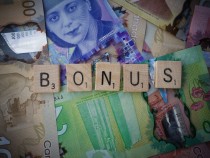 Scrabble letters spelling 'bonus' on Canadian bills