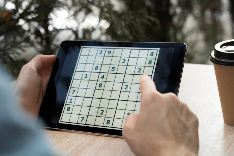 Person playing sudoku on a tablet