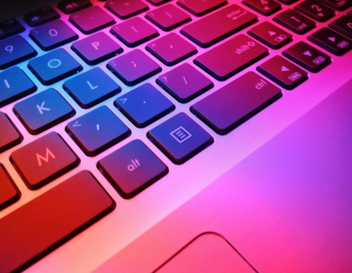 a close up of a laptop keyboard with red and blue keys
