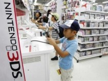 Boys try out Nintendo's 3DS game software at an electronic store in Tokyo July 25, 2012.