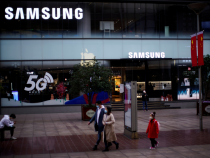 FILE PHOTO: People wears masks in front a Samsung Store at a main shopping area, in downtown Shanghai